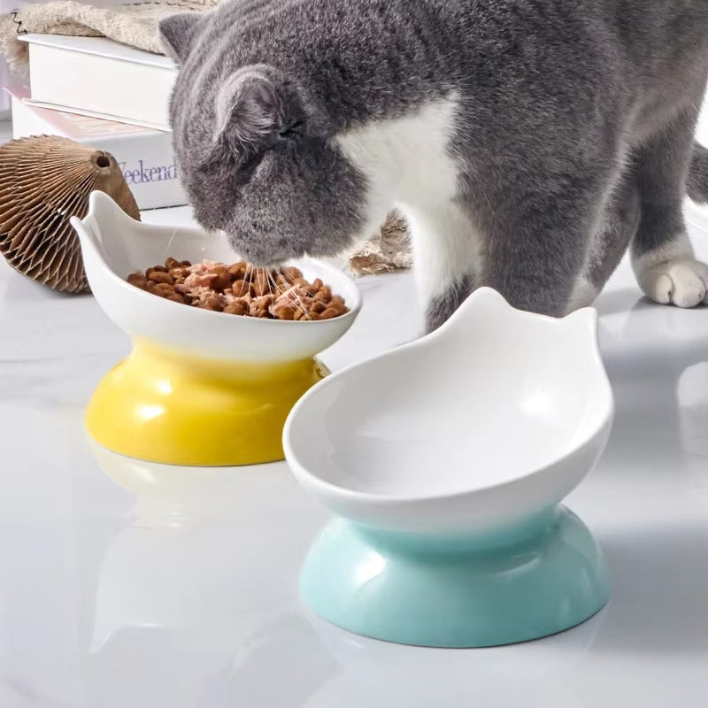 Katze frisst aus einem erhöhten Catson Neko Dish™ Keramik-Futternapf in Gelb, daneben ein weiterer Napf in Blau